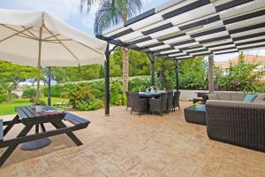 un patio con tavoli, sedie e ombrellone di Villa Astrid a Protaras