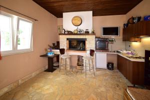 a kitchen with a table and chairs and a fireplace at VILLA DINJA in Gizdavac