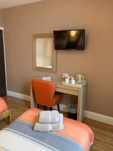 a bedroom with a desk and a bed with a chair at Central Hotel in Sutton in Ashfield