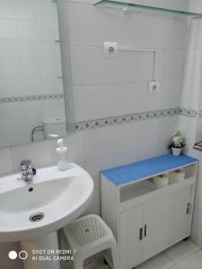 een witte badkamer met een wastafel en een spiegel bij Apartamento Casco Antiguo Ponferrada in Ponferrada