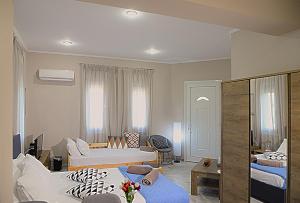 a hotel room with two beds and a living room at Mastiha Villas in Town in Chios