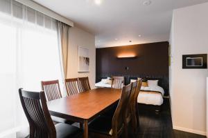 a room with a table and chairs and a bed at GRAND BASE Fukuoka in Fukuoka