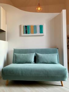 un sofá azul en una habitación con una pintura en Indipendenza Luxury Apartments, en Bolonia
