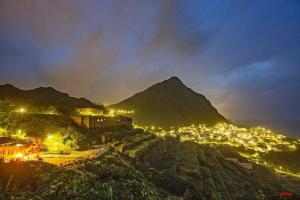 a view of a city at night with a mountain at 13F Homestay in Jiufen