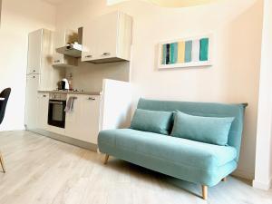 a living room with a blue couch and a kitchen at Indipendenza Luxury Apartments in Bologna