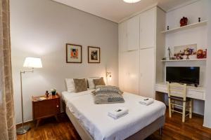 um quarto com uma cama, uma secretária e uma televisão em Victoria Jewels em Atenas