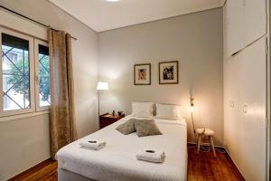 um quarto com uma cama branca com duas toalhas em Victoria Jewels em Atenas