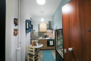 uma pequena cozinha com uma pequena mesa e uma cozinha com um balcão em Victoria Jewels em Atenas