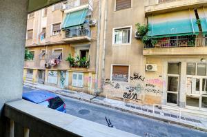 um edifício com graffiti ao lado de uma rua em Victoria Jewels em Atenas