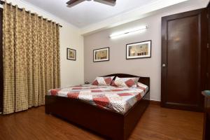a bedroom with a bed with a checkered blanket at 2BHK Comfortable Furnished Serviced Apartments in Hauz Khas - Woodpecker Apartments in New Delhi