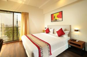 - une chambre avec un grand lit et une grande fenêtre dans l'établissement Mumbai House Luxury Apartments Santacruz East, Mumbai, à Mumbai