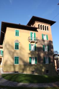a large building with green shutters on it at Garnì Villa Waiz in Roncegno