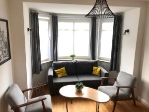 ein Wohnzimmer mit einem Sofa, 2 Stühlen und einem Tisch in der Unterkunft Haus Schönkamp in Lübeck