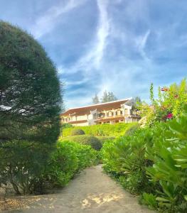 une maison au milieu d'un jardin avec des buissons dans l'établissement Villa Louise Hue Beach Boutique Hotel, à Hue