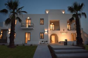 a large white house with palm trees in front of it at Angels Pillow Luxury Boutique Residence - Adults Only in Naousa