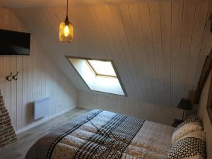 a attic bedroom with a bed and a window at Appartement style industriel avec terrasse in Givet