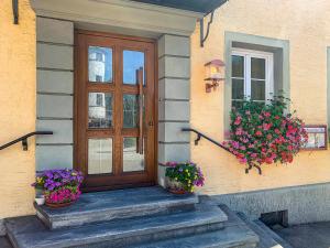 una puerta de entrada de una casa con dos macetas de flores en Hotel Post Leutkirch en Leutkirch im Allgäu