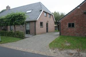 a brick house with a driveway in front of it at De Pompstee Rolde in Rolde