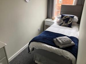 Cama pequeña en habitación pequeña con ventana en 34 Brunton Street Serviced Accommodation, en Darlington