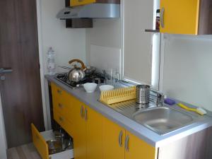 a small kitchen with a sink and a stove at Victoria Mobilehome Camping Imperial in Vodice