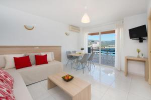 ein Wohnzimmer mit einem Sofa und einem Tisch mit Aussicht in der Unterkunft Apartamentos Calablanca in Palmanova