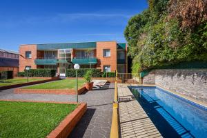 a building with a swimming pool in front of a building at APX Parramatta in Sydney