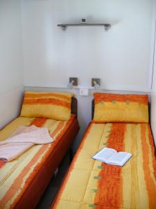 twee bedden naast elkaar in een kamer bij Victoria Mobilehome in Centro Vacanze San Francesco in Duna Verde