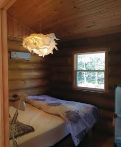 a bedroom in a log cabin with a chandelier at Sunrise Pines in Colpton