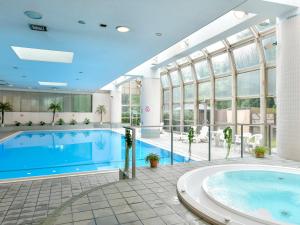 ein großer Pool mit einem großen Zimmer mit Fenstern in der Unterkunft Narita Tobu Hotel Airport in Narita