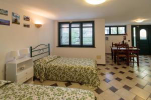 1 dormitorio con 2 camas y comedor con mesa en Affittacamere Chez nouse en Massarosa