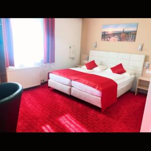 ein Schlafzimmer mit einem großen Bett und einem roten Teppich in der Unterkunft Hotel Aragia GmbH in Klagenfurt am Wörthersee + 28 Fotos