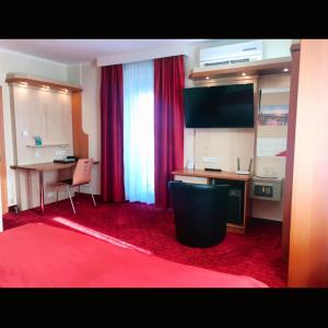 Camera con scrivania e tappeto rosso. di Hotel Aragia a Klagenfurt