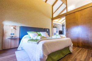 1 dormitorio con 1 cama grande con sábanas blancas y almohadas verdes en Casa Costiña, en Cotobade 61 fotos más
