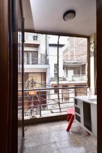 a room with a balcony with a view of a building at 2BHK Comfortable Furnished Serviced Apartments in Hauz Khas - Woodpecker Apartments in New Delhi