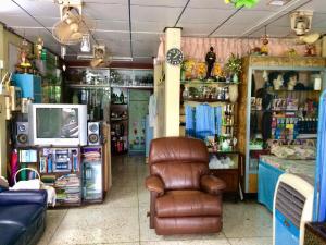 a room with a chair and a tv in a store at PEE HOMESTAY LOPBURI in Ban Tha Krayang
