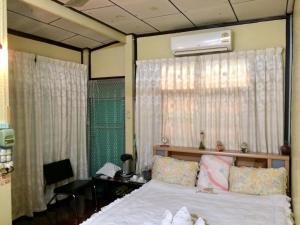 a bedroom with a white bed and a window at PEE HOMESTAY LOPBURI in Ban Tha Krayang