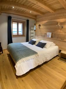 a bedroom with a large bed in a wooden wall at Le Gabion, luxueux appartement avec 10 couchages et sauna, Serre chevalier Vallée in Saint-Chaffrey