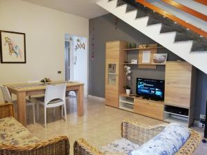 a living room with a dining room table and a kitchen at Villa Malu in Anzio