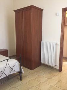 a bedroom with a wooden cabinet next to a radiator at Agriturismo da Regina in Tramonti