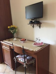 a desk with a television on a wall with a chair at Agriturismo da Regina in Tramonti