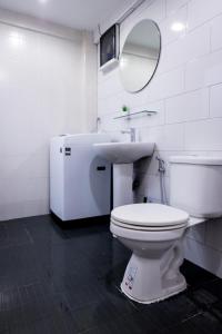 bagno con servizi igienici, lavandino e specchio di T1 Large Studio Full kitchen 100m. to BTS a Bangkok