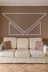 un divano bianco con due cuscini su un muro di Villaggio Smeralda by Sardegna Smeralda Suite a Porto Rotondo