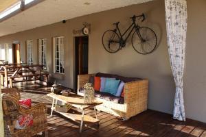a bike hanging on a wall above a couch on a porch at Mon Reve in Lephalale