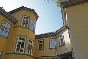 ein gelbes Gebäude mit weißen Fenstern auf einer Straße in der Unterkunft Gästehaus Nikolai in Erfurt