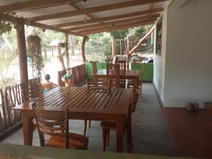 a porch with wooden tables and chairs and a playground at Pidurangala View Home Stay in Sigiriya