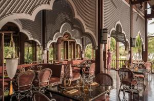 a restaurant with tables and chairs and people in the background at Four Seasons Resort Langkawi in Tanjung Rhu