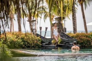 a woman in a white dress standing in a swimming pool at Four Seasons Resort Langkawi in Tanjung Rhu