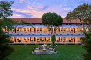 an exterior view of a building with a courtyard at Hotel Majapahit Surabaya MGallery in Surabaya