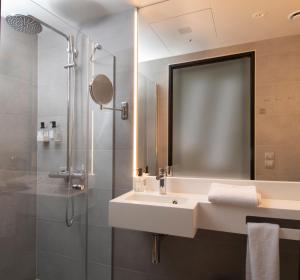La salle de bains est pourvue d'un lavabo et d'une douche. dans l'établissement Mandal Hotel, à Mandal