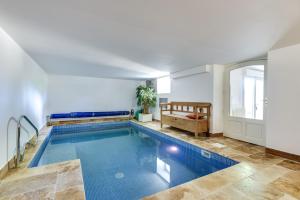a large swimming pool in a white room with at SUITE Souplex Château Côte de Nacre in Ver-sur-Mer